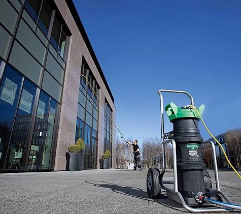 Machine à eau osmosée Unger HydroPower et perche télescopique en intervention sur les vitres d'un immeuble de bureaux